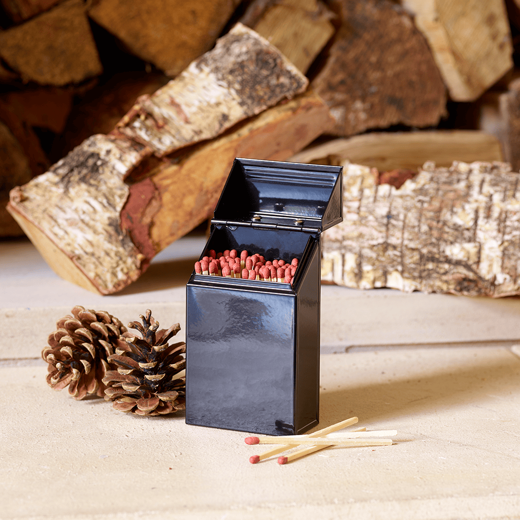 Lifestyle image of Valiant Match Tidy open on hearth with logs and pinecones
