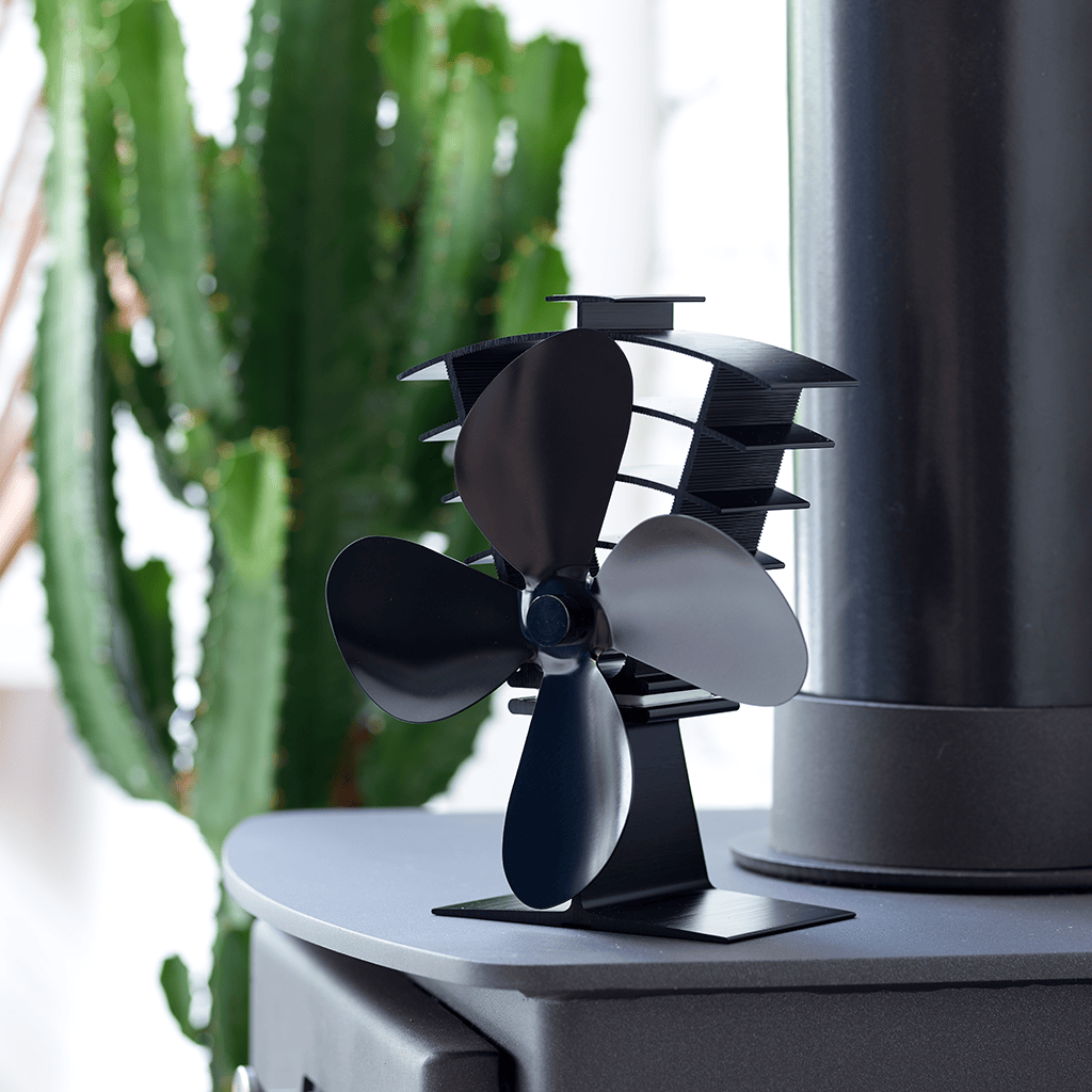 Lifestyle image of Valiant Heat Powered Stove Fan sitting on top of a wood burning stove